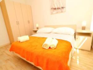 a bedroom with a bed with two towels on it at Apartments Seafront Silence - One Bedroom Apartment with Terrace and Sea View in Trstenik