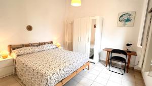 a bedroom with a bed and a desk and a chair at la casetta di Ponente in San Bartolomeo al Mare