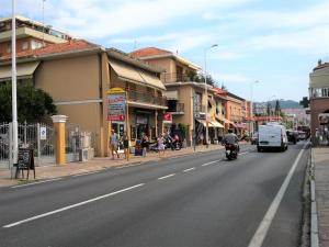 a street in a town with a man on a motorcycle at la casetta di Ponente in San Bartolomeo al Mare