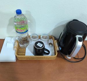 a picnic basket with a bottle of water and glasses at Kampung vibes with good location in Kota Bharu