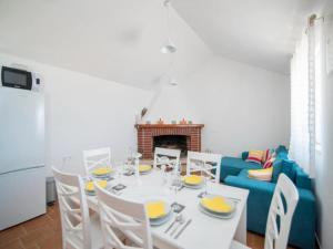 ein Esszimmer mit einem weißen Tisch und einem blauen Sofa in der Unterkunft Holiday Home My Summer House - Two-Bedroom Holiday Home with Private Pool and Terrace - ST in Supetar