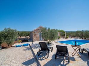 eine Terrasse mit zwei Stühlen und einem Swimmingpool in der Unterkunft Holiday Home My Summer House - Two-Bedroom Holiday Home with Private Pool and Terrace - ST in Supetar