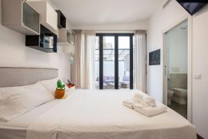 a bedroom with a large white bed with towels on it at Cottage with Garden and Terrace near Termini in Rome