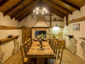 ein Esszimmer mit einem Holztisch und einem Kamin in der Unterkunft Villa Falcon Rook - Four-Bedroom Villa with Terrace and Swimming Pool in Dubravka