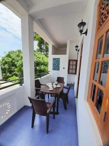 a dining room with a table and chairs and a balcony at Jasmine Apartments in Negombo