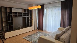 a living room with a couch and a flat screen tv at Oasis Apartment in Cluj-Napoca