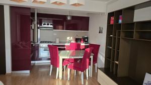 a kitchen with a dining table and red chairs at Oasis Apartment in Cluj-Napoca