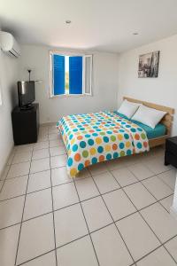 ein Schlafzimmer mit einem Bett und einem gefliesten Boden in der Unterkunft La Maison du Bonheur & Escapade Côte Bleue in Martigues + 2 Fotos