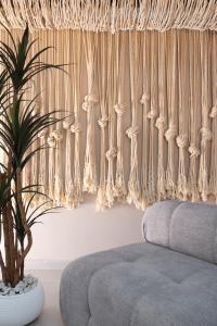 a living room with a couch and a potted plant at Silk Athens Urban Collection in Athens +51 photos