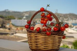 a basket filled with eggs and tomatoes on a table at Stefanos Studios in Skala