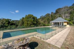 a large swimming pool with a gazebo next to at Flametrees in Jamberoo +36 photos