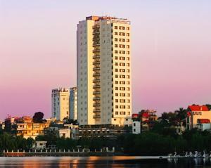 a tall white building in front of a city at Skyline Tower - Service Apartments in Hanoi