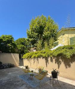 un patio con 2 sedie e un tavolo accanto a un muro di Charmant appartement Port & Plages ! a Bandol