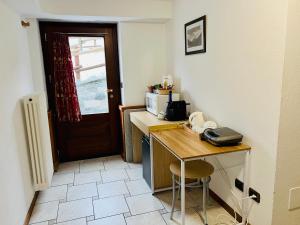 a small kitchen with a table and a microwave at Affittacamere Buenavista Guest House in Champoluc
