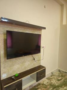 a flat screen tv hanging on a wall at Pandit Devki Nandan Dharamsala & Guest House in Deoghar