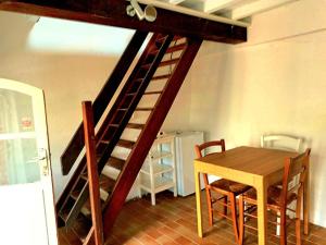 a wooden staircase in a room with a table and a dining room at Charming brickyard cottage near a lock in Ayguesvives +13 photos