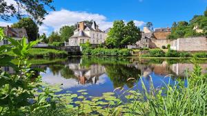 a river in a town with houses and buildings at Apartment in Downtown in Châteaubriant