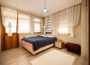 Un dormitorio con una cama en una habitación con ventanas. en Doğa ile iç içe, en Çukurçayır