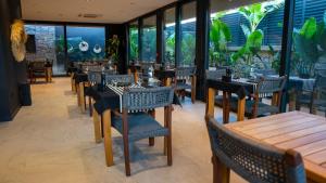 a restaurant with tables and chairs and windows at The Grey Alaçatı in Çeşme