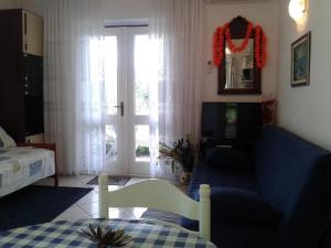 a living room with a blue couch and a window at Apartments Marina in Supetar
