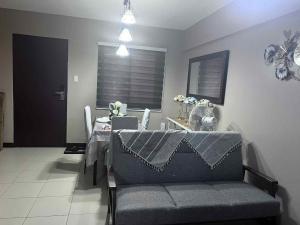 a living room with a gray couch and a table at The Haru at Arista in Manila
