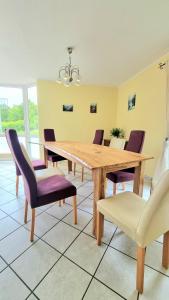 a dining room with a wooden table and purple chairs at Ferienhaus Engelhardt in Ebergötzen