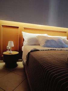 a bedroom with a bed with a headboard and a lamp at La Casetta di Giadapia - Apulia Houses & Flats in Ruvo di Puglia