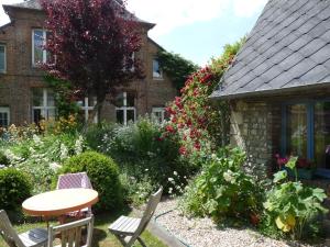 a garden in front of a house with a table and chairs at Studio duplex L'Ecole Buissonnière in Trouville-la-Haule