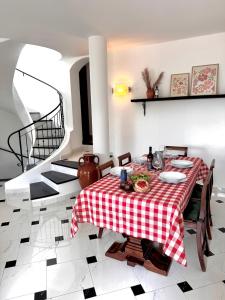 a dining room with a red and white checkered table at La Casa negli Ulivi - con vista Mare in Arnasco