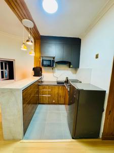una cucina con frigorifero nero e armadietti in legno di Ivanna stay kuleshwor K4 a Kathmandu