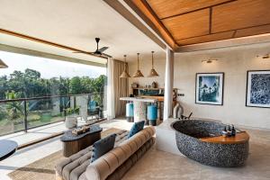 a living room with a large couch and a large tub at Soulshine Resort Ubud, Bali in Ubud