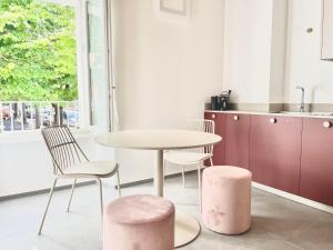 a kitchen with a table and two pink stools at Dimora dell'Ulivo in Verucchio