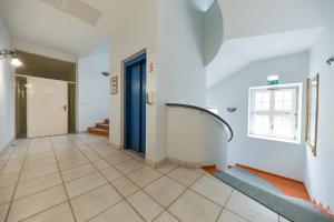 a hallway with a blue door and a tile floor at Apartments at Villa Golf in Rogaška Slatina