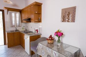 a kitchen with a table with a vase of flowers on it at Stefanos Studios in Skala