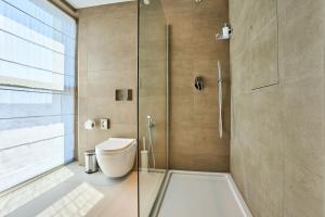 a bathroom with a toilet and a glass shower at Luxurious Level 26 Getaway in St. Julianʼs