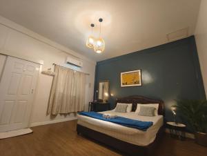 a bedroom with a bed with a blue accent wall at kanya house 3 bedroom for 6 paxs whole house in Hat Yai