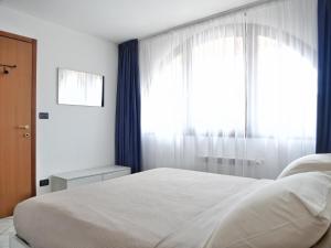 アクイレイアにあるAquileia Apartmentの白いベッドと窓のある寝室