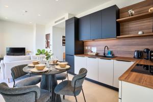 a kitchen and living room with a table and chairs at Luxurious Level 26 Getaway in St. Julianʼs