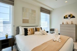 a bedroom with a white bed with stuffed animals on it at Luxurious Level 26 Getaway in St. Julianʼs
