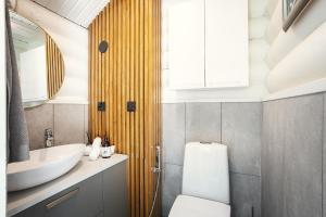 a bathroom with a white toilet and a sink at Stay North - Ösund in Helsinki +99 photos