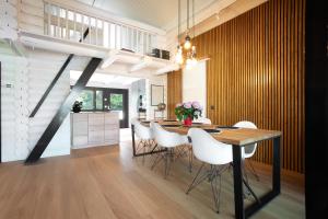 a dining room with a table and white chairs at Stay North - Ösund in Helsinki