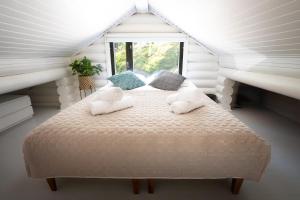 a bedroom with a bed with pillows and a window at Stay North - Ösund in Helsinki
