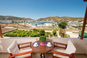 a table and chairs on a balcony with a view of a harbor at Stefanos Studios in Skala