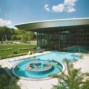 a large swimming pool in front of a building at Hotel Seeblick in Saalburg