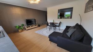 a living room with a black couch and a table at bei Elena in Burscheid