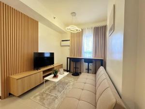 a living room with a couch and a flat screen tv at Escarlett 1 Bedroom 15th Floor Cagayan de Oro in Pontud