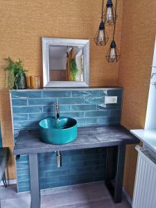a bathroom with a blue sink and a mirror at Moderne Ferienwohnung Am Flohbach 1 in Floh
