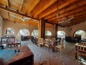 a dining room with tables and chairs and wooden ceilings at New star hotel in Siwa