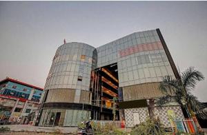 a large glass building with a tree in front of it at the valentine hotel in Surat