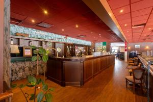 a restaurant with a counter and a bar at Injoy Classic Hotel Halmstad in Halmstad